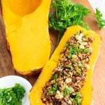 2 halves of a baked butternut squash one is stuffed with rice and one plain