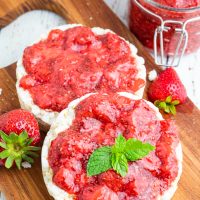 2 rice cakes topped with chia jam and canning jar filled with strawberry jam