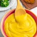 colorful red and yellow bowl filled with sweet potato cheese sauce