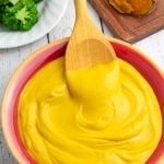 colorful red and yellow bowl filled with sweet potato cheese sauce