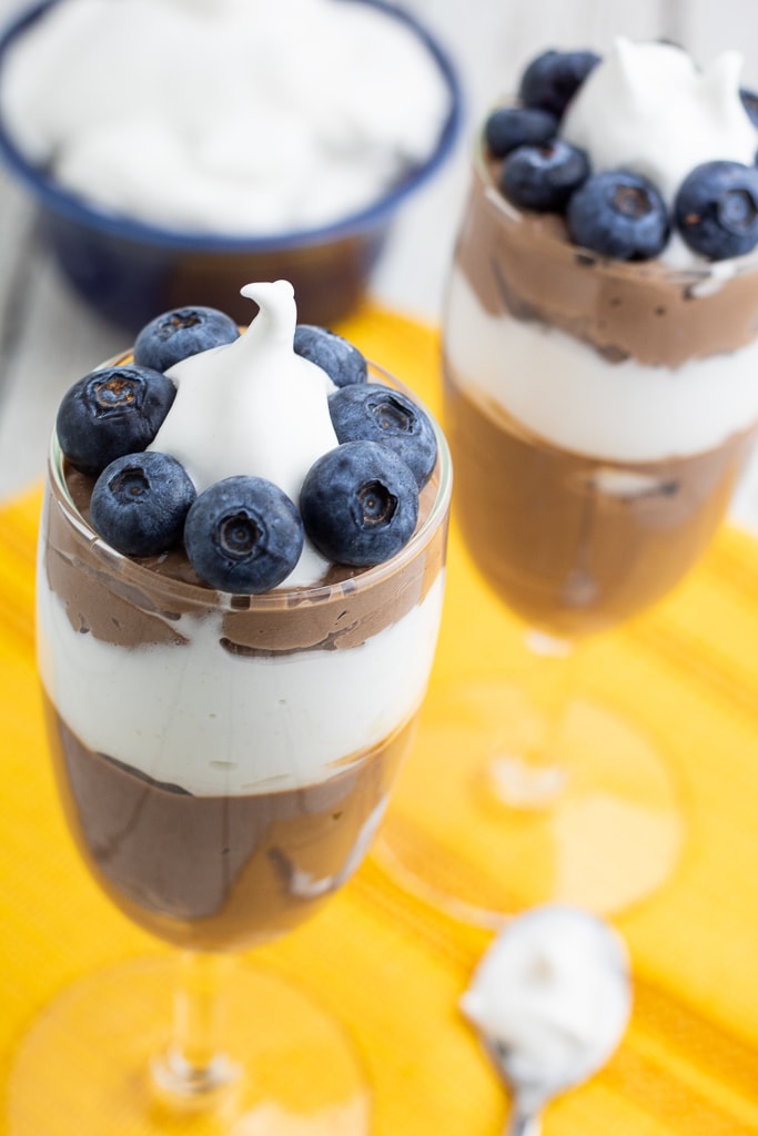 dessert glasses filled with vegan chocolate mousse and whipped cream
