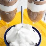 bright blue bowl full of vegan whipped cream with dessert in background