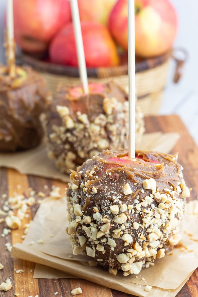 date caramel apples covered in nuts on brown paper