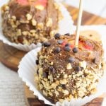 vegan caramel apples covered in peanuts and chocolate chips