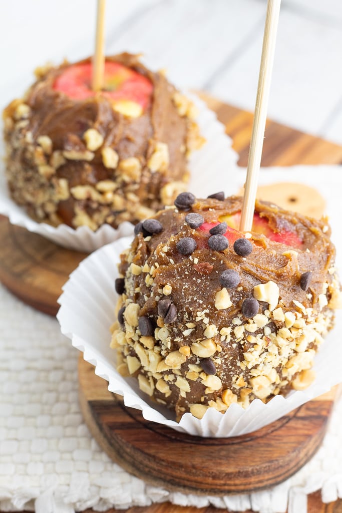 vegan caramel apples covered in peanuts and chocolate chips
