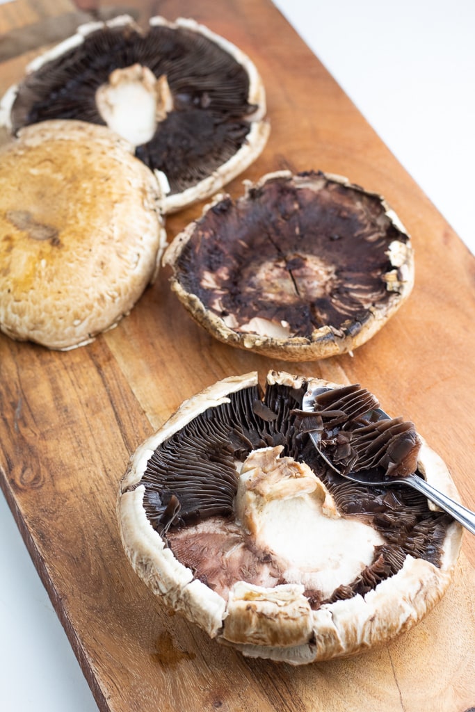 portobello mushroom caps on cutting board
