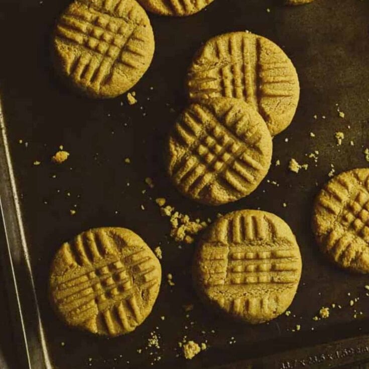 peanut butter cookies on dark baking sheet