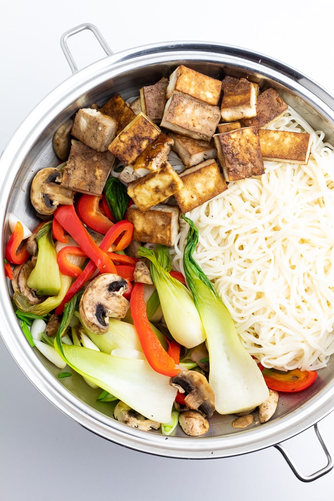 stainless wok filled with tofu, veggies, and noodles