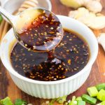 white bowl with spoonful of teriyaki sauce on wooden board