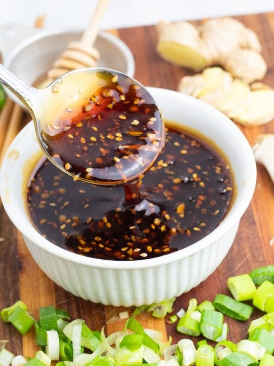white bowl with spoonful of teriyaki sauce on wooden board