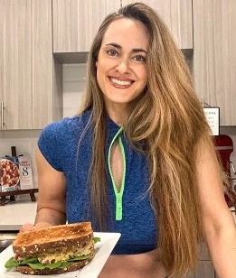 Brandi with Vegan 8 in kitchen holding plate of food