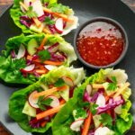 Vegetable lettuce wraps with carrot, onion, radish, red cabbage, cucumber and sweet chilli sauce.
