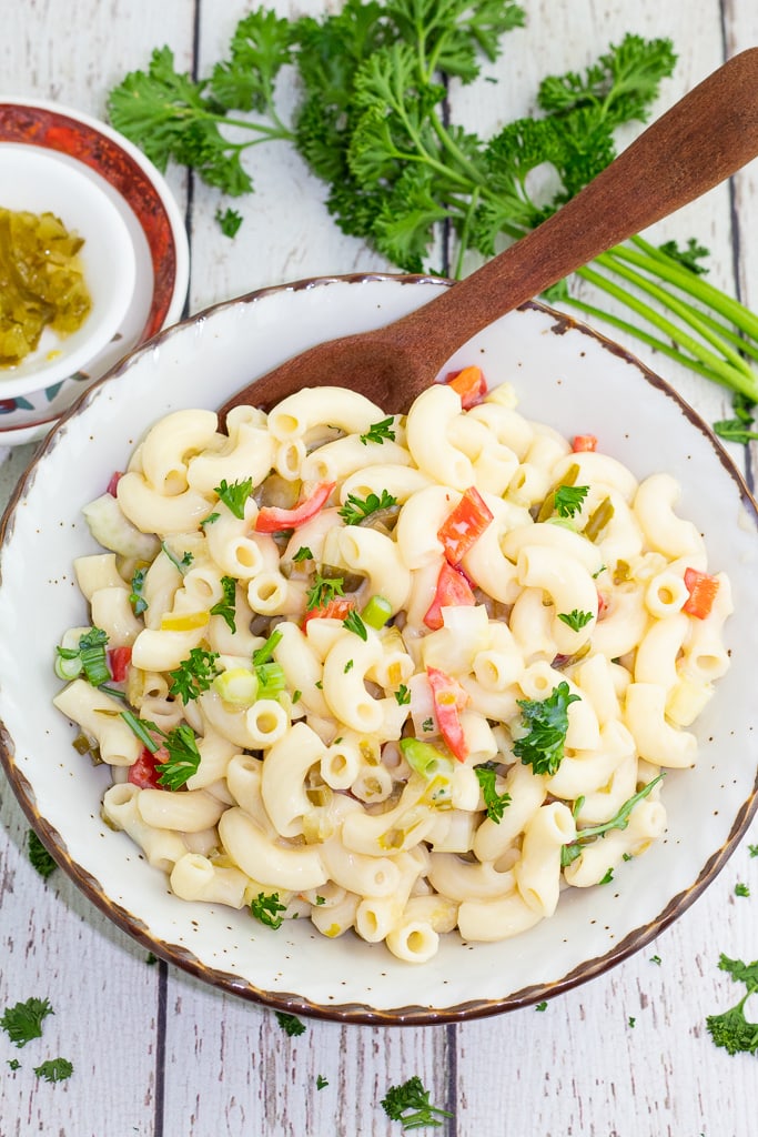 white bowl with macaroni salad and wooden spoon