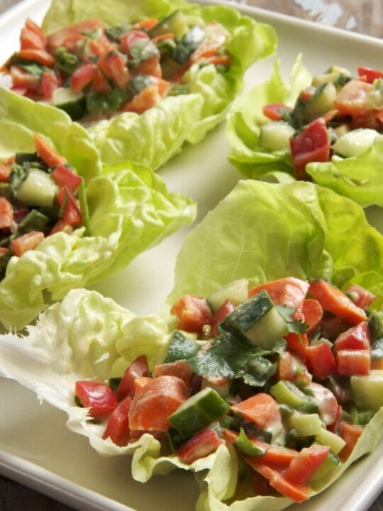 lettuce wraps stuffed with veggies on white platter