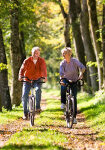 senior man and woman riding bikes out in nature