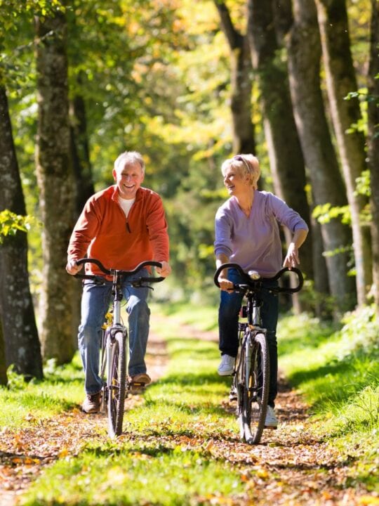 senior man and woman riding bikes out in nature