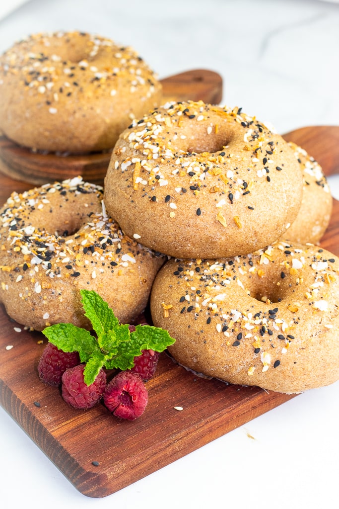 stacked whole wheat bagels on cutting board