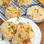 overhead photo of white plate with fried green tomatoes with more on cooling rack in background