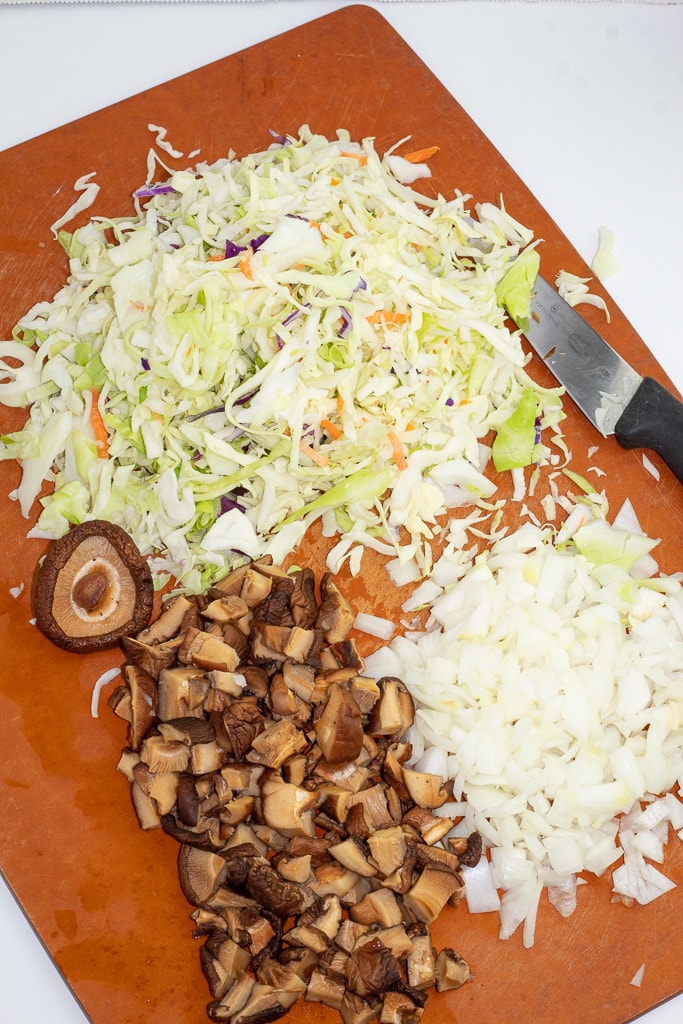diced cabbage, onions, and mushrooms on cutting board