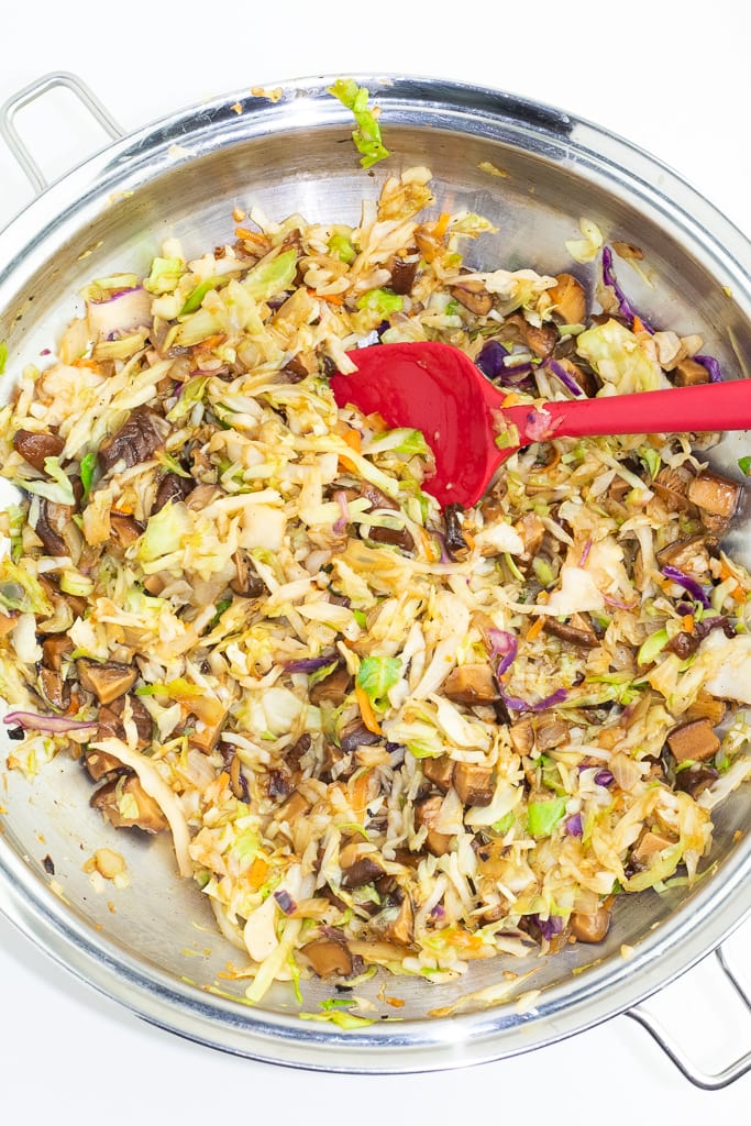 stainless wok with cooked cabbage, mushrooms, onions