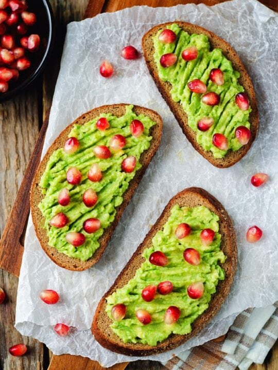 3 slices of avocado toast on a cutting board