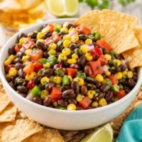 black bean corn salsa in a white bowl with cornchips.