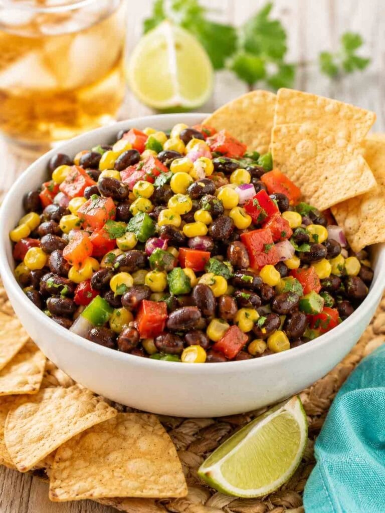 black bean corn salsa in a white bowl with cornchips.