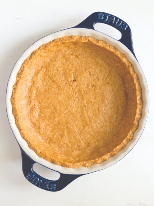 overhead photo of graham cracker crust in white and blue pie pan