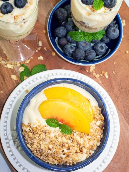 overhead shot of blue bowl filled with vegan yogurt and topped with granola and fruit