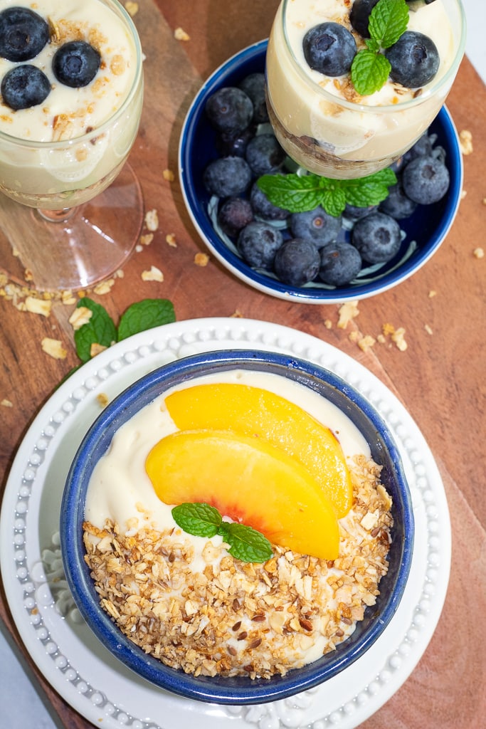 overhead shot of blue bowl filled with vegan yogurt and topped with granola and fruit