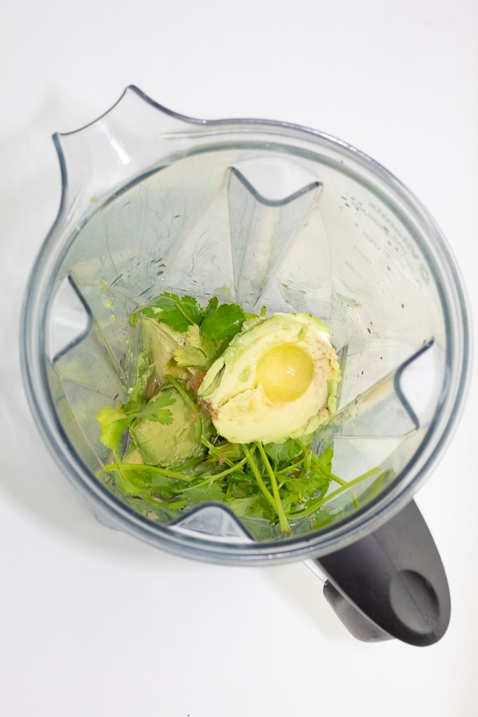 blender with avocado dressing ingredients before blended