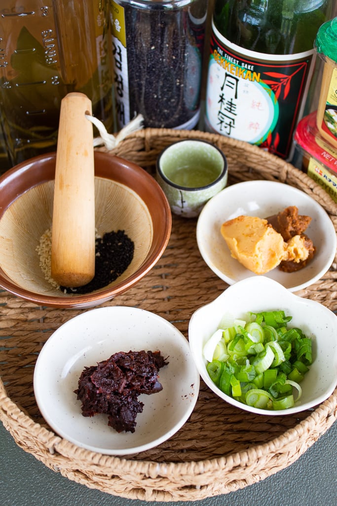 ingredients for miso ramen soup base bean paste, sesame seeds, green onions, miso in basket