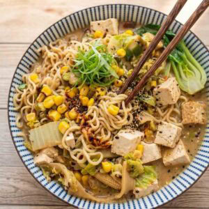 miso ramen with tofu and vegetables in a colorful bowl with chopsticks.