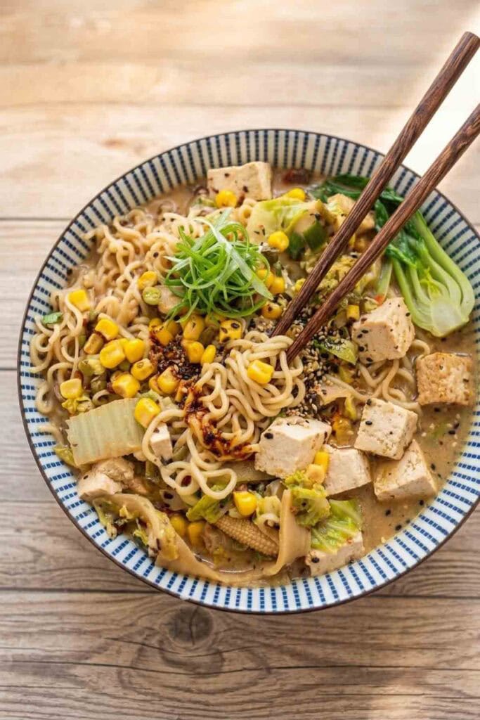 miso ramen with tofu and vegetables in a colorful bowl with chopsticks.