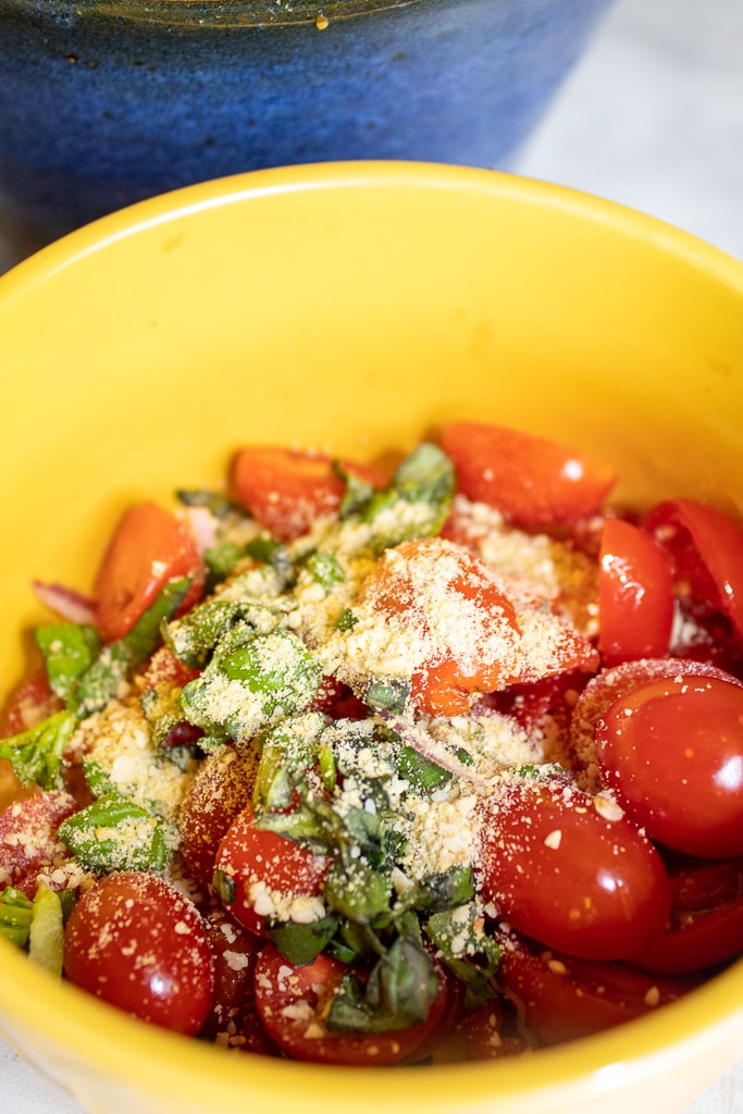 bowl with tomatoes, basil, and vegan parmesan