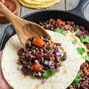bean taco filling being spooned into a soft tortilla.