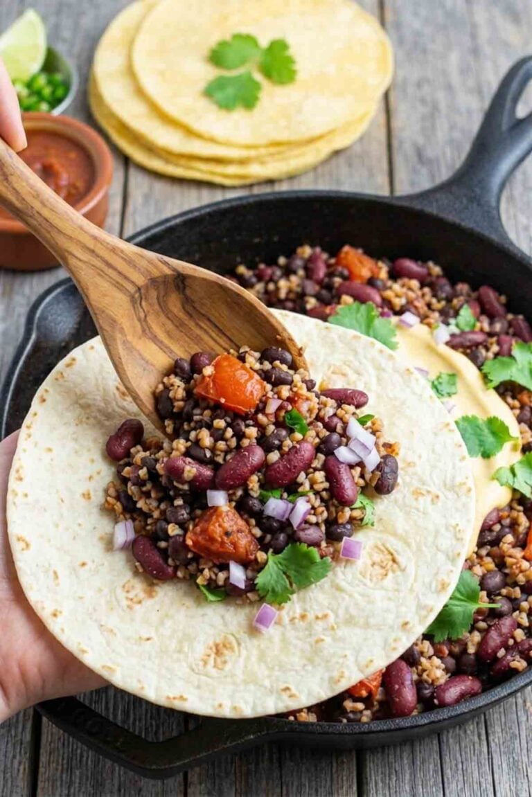 bean taco filling being spooned into a soft tortilla.