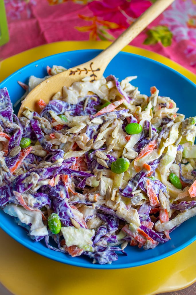 bright blue bowl with asian cabbage salad and wooden spoon