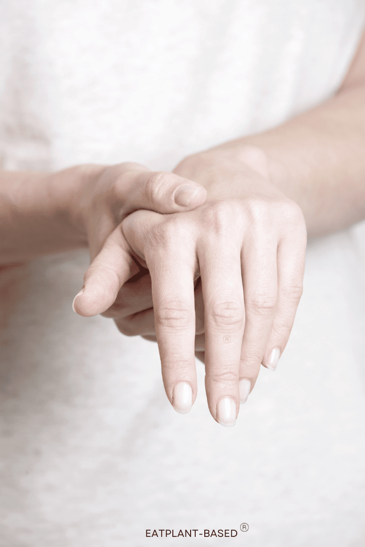 woman rubbing painful hands with arthritis
