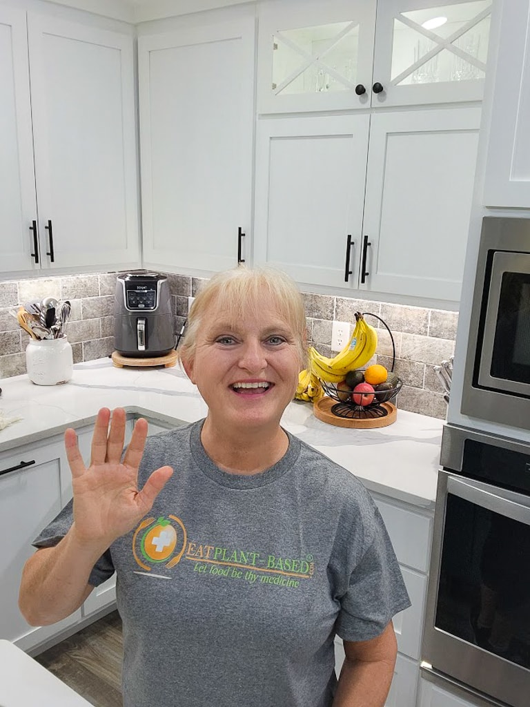 terri edwards modeling her gray eatplant-based tshirt in kitchen and waving