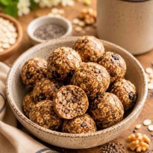 bowl of oatmeal energy balls with one sliced open to see the texture inside.