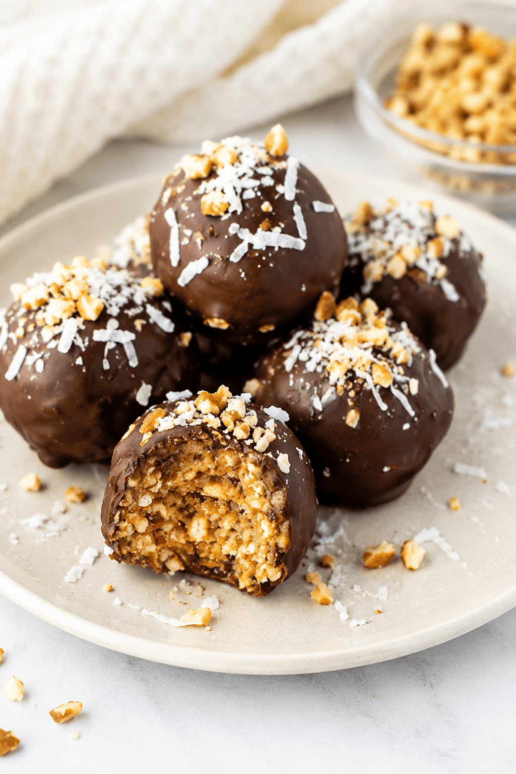 dairy-free chocolate balls on a white plate with one bite out of the first ball.