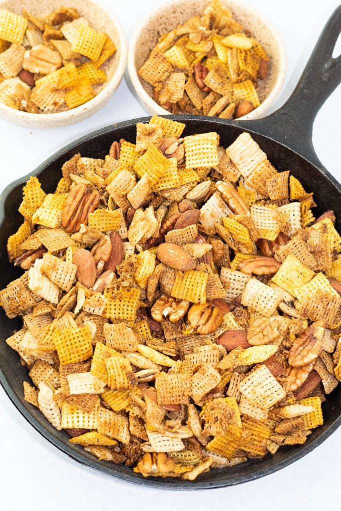 black iron pan with handle full of chex party mix