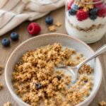 bowl of chewy peanut butter granola in a bowl with milk and a spoon.