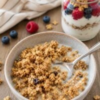 bowl of chewy peanut butter granola in a bowl with milk and a spoon.