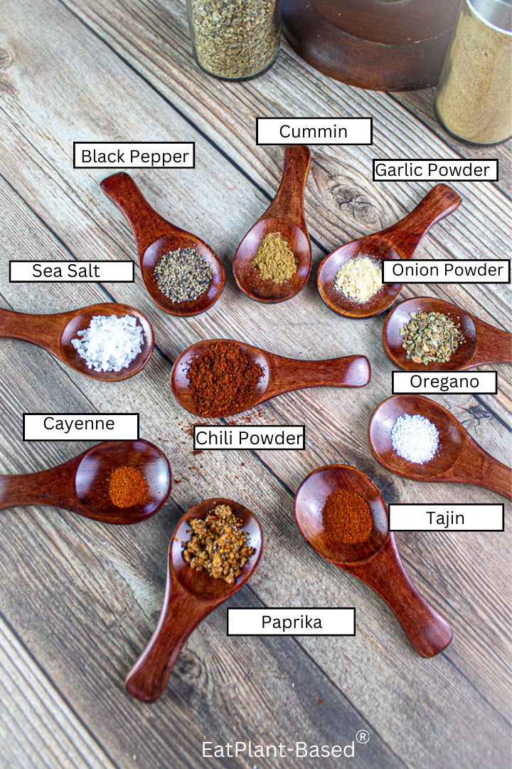wooden measuring spoons filled with spices and labeled with names of spices