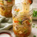 asian noodle mason jar soup with a fork pulling noodles out.
