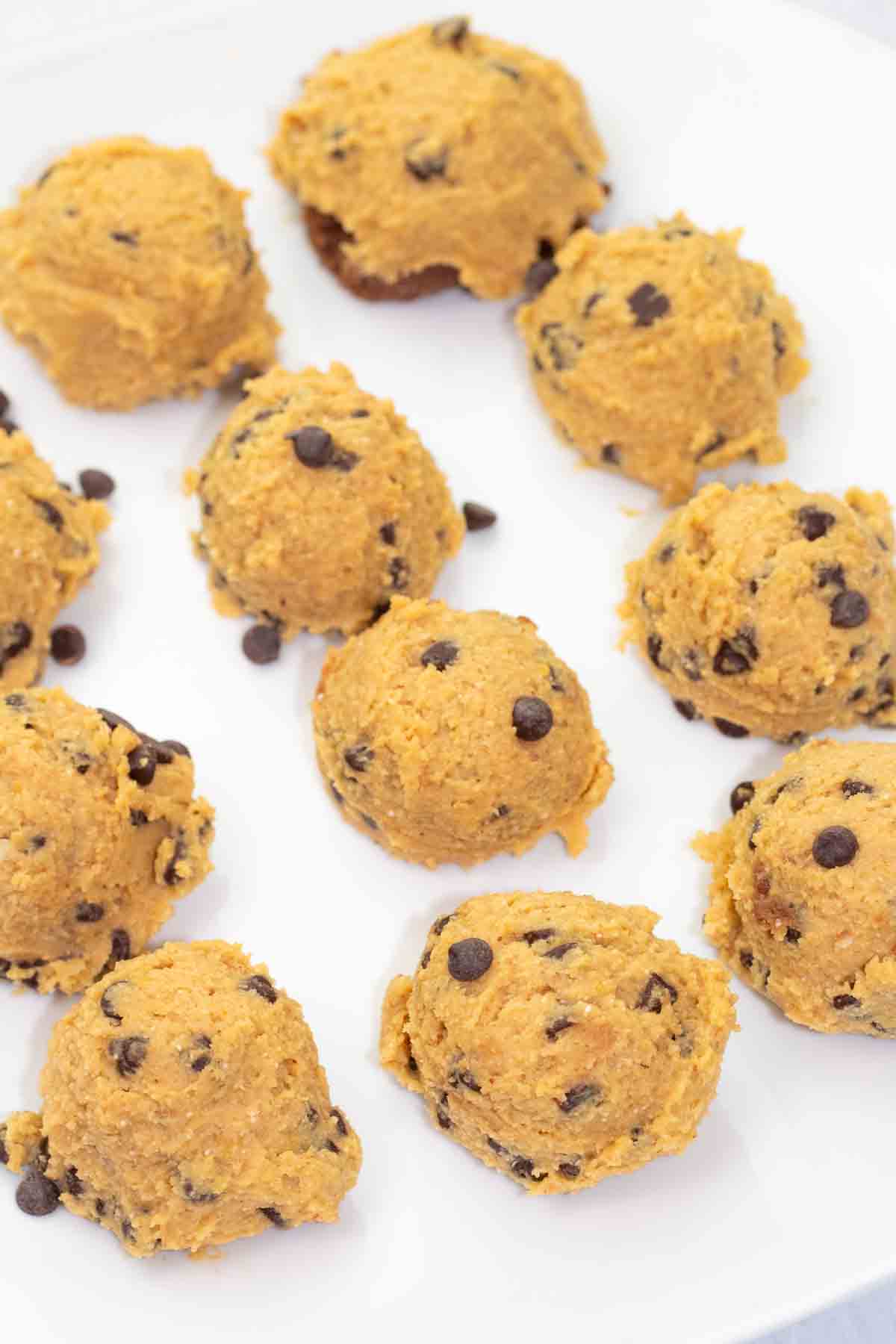 vegan raw cookie dough balls on a white platter.