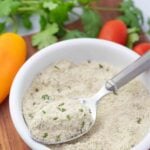 vegan ranch seasoning mix in a white bowl with a spoon.