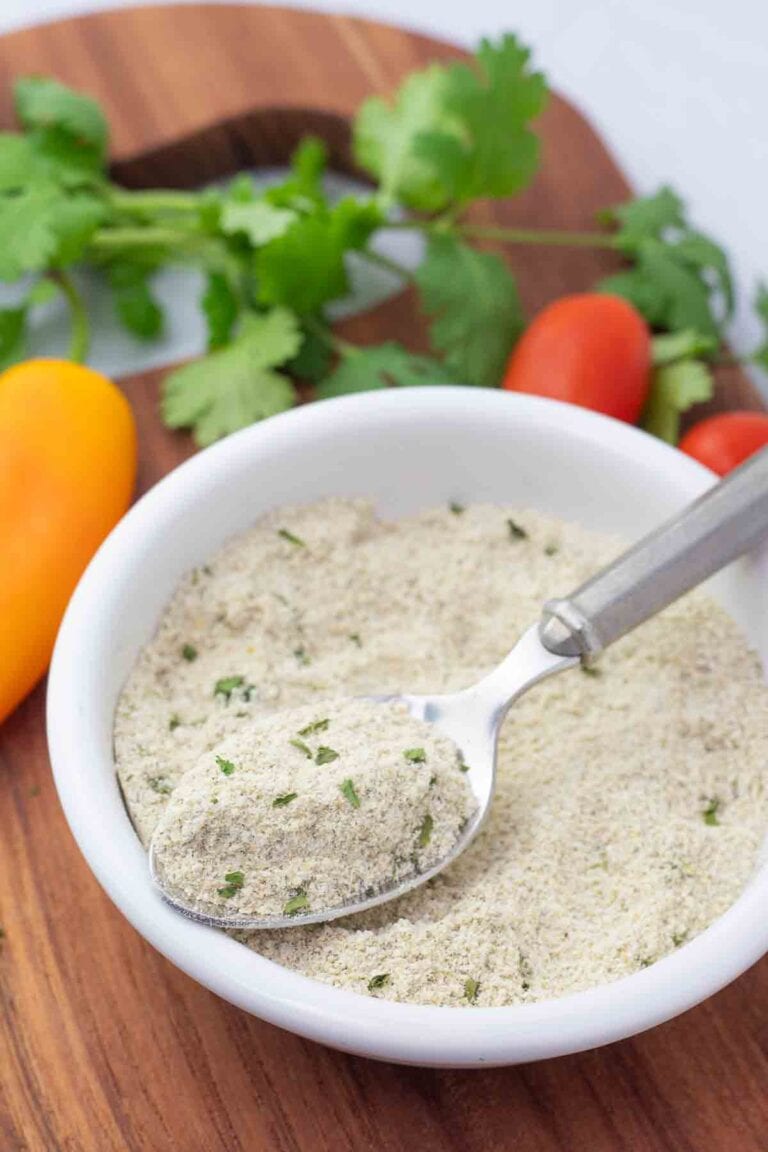 vegan ranch seasoning mix in a white bowl with a spoon.